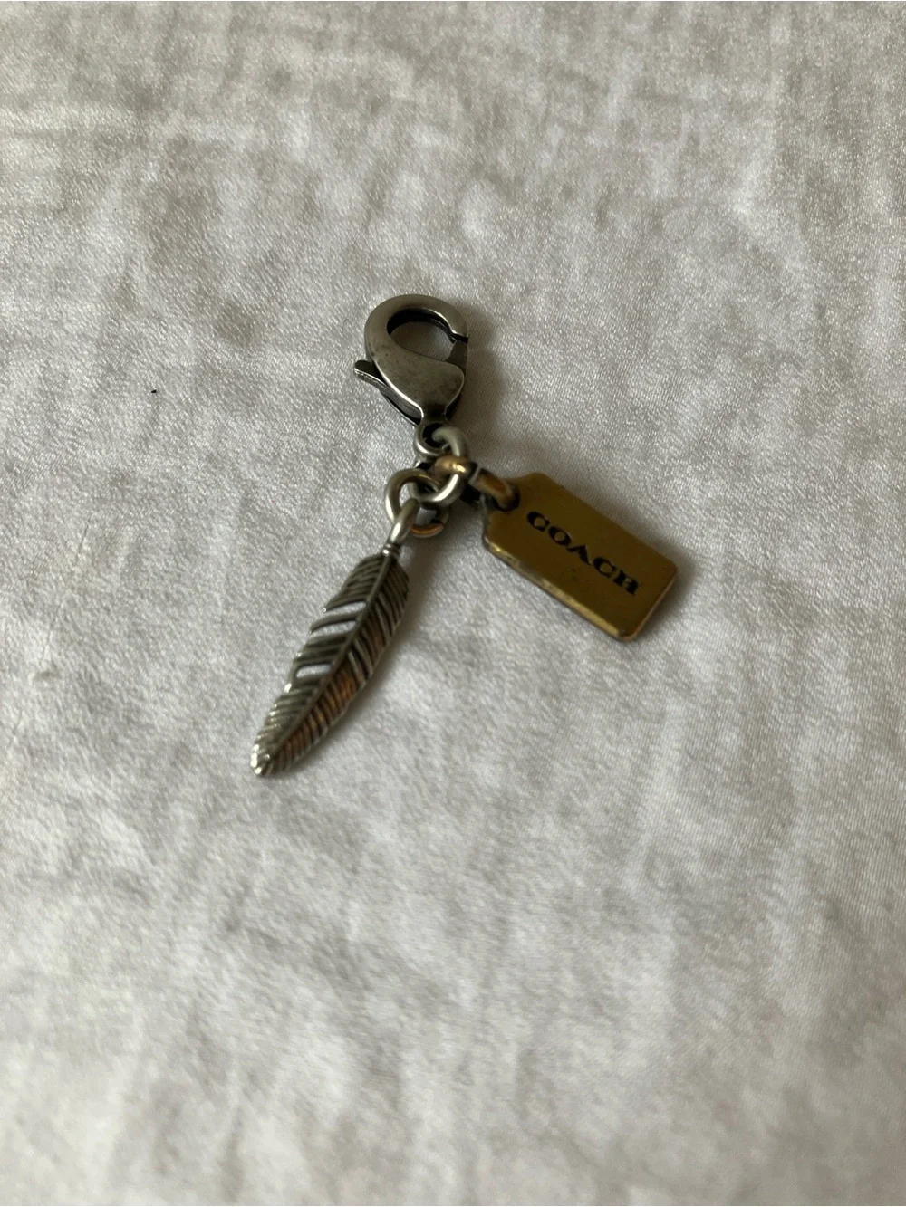 Coach: Silver Tone & Gold Tone Feather Charm Keyring
